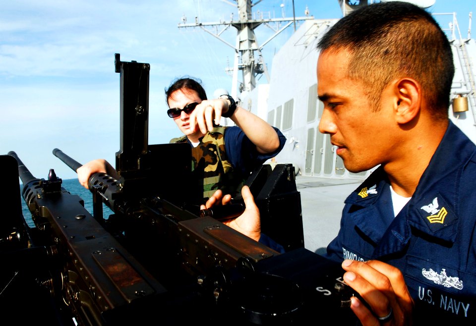 US Navy 090424-N-9928E-067 Gunner's Mate 1st Class Eddieesther Trinidad, left, from San Diego, Calif., helps Gunner's Mate 3rd Class Casey Gil, from Newaygo, Mich., load a .50-caliber machine gun