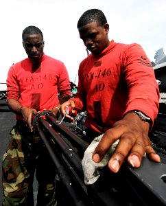US Navy 090423-N-6538W-082 Aviation Ordnanceman 2nd Class Jamel Marin and Aviation Ordnanceman Airman Omar Richardson perform routine maintenance on an M61-A1, 20mm Gatlin gun