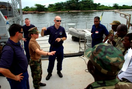 US Navy 090427-N-1655H-278 Coast Guard Machinery Technician 2nd Class David Moyer, assigned to the International Training Division, center, reviews visit, board, search and seizure techniques with Gabonese sailors