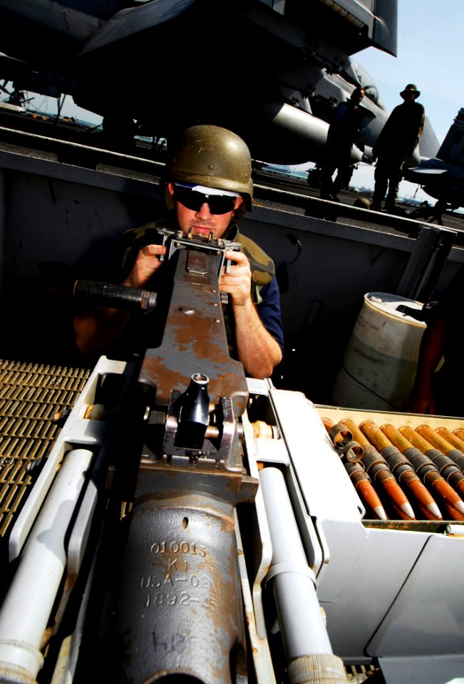 US Navy 090424-N-6538W-020 Gunner's Mate 3rd Class Collin Naylor, from San Jose, Calif., stands a .50-caliber machine gun force protection watch aboard the aircraft carrier USS John C. Stennis (CVN 74) as the ship transits Sing