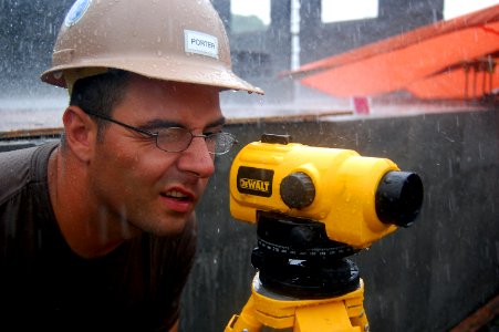 US Navy 090424-N-1057H-466 Engineering Aide Constructionman Travis C. Porter takes measurements in the rain during construction at the Hamramba School Project photo