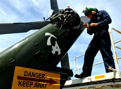 US Navy 090424-N-7280V-259 Aviation Machinist's Mate Airman Christopher Cockroft installs a tail gear box cover on an SH-60F Sea Hawk