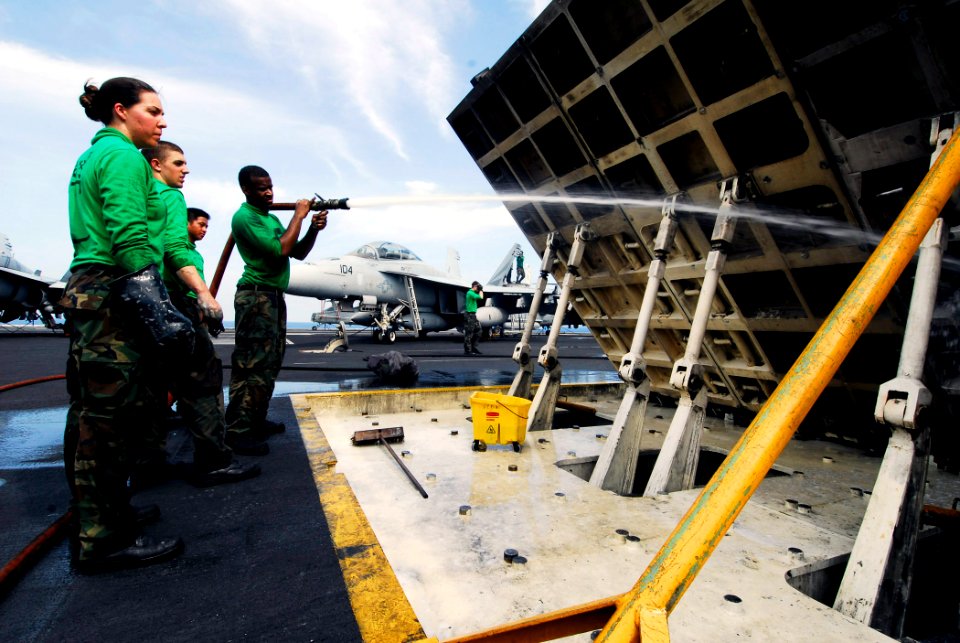 US Navy 090423-N-6538W-232 Aviation Boatswain's Mates clean off dirt and grease from a jet-blast deflector during a scrub down on the flight deck of the aircraft carrier USS John C. Stennis (CVN 74)