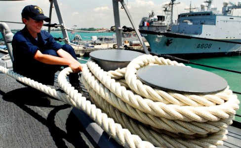US Navy 090424-N-9928E-115 Boatswain's Mate Seaman Angelica Zielstorf, from Davenport, Iowa, wraps a mooring line around a bit on the forecastle aboard the Arleigh Burke-class guided-missile destroyer USS Kidd (DDG 100) as the