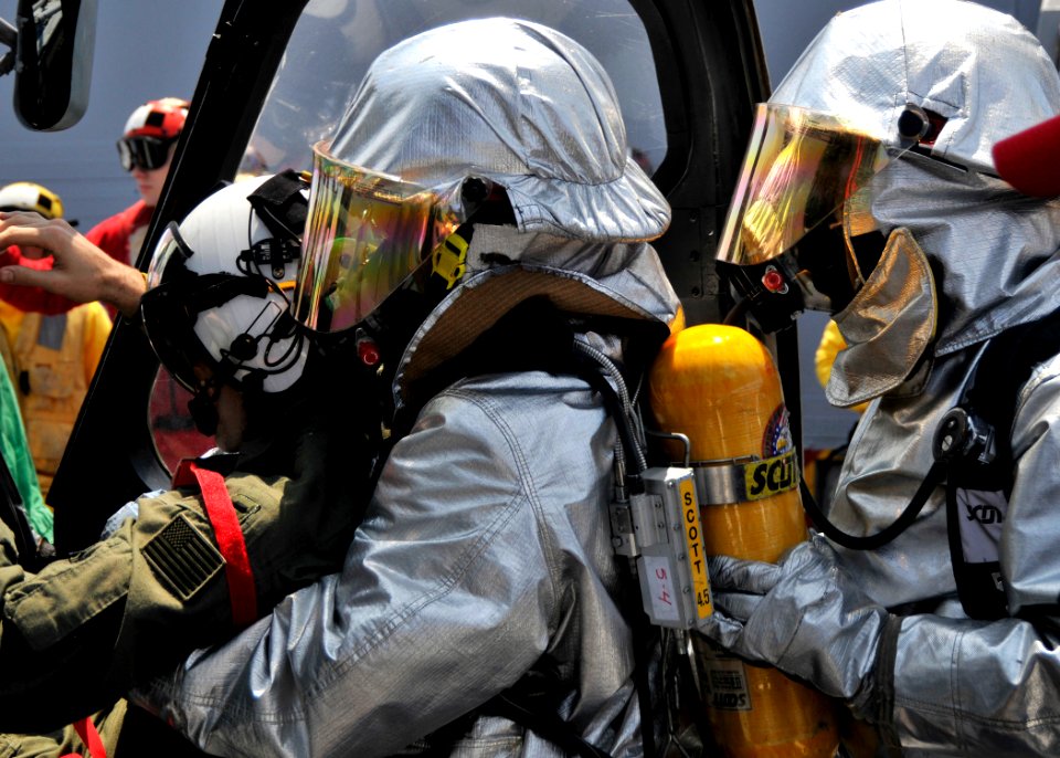 US Navy 090428-N-2638R-001 Ship's Serviceman Seaman Johnnie Jackson and Damage Controlman Fireman Terrel Rowan, both from Houston, wear hot suits as they assist the pilot of an SH-60B Sea Hawk