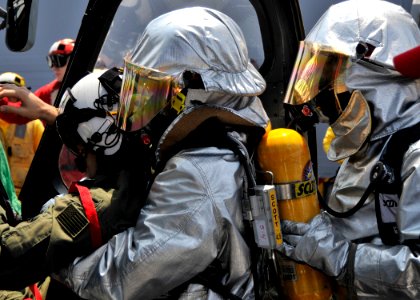 US Navy 090428-N-2638R-001 Ship's Serviceman Seaman Johnnie Jackson and Damage Controlman Fireman Terrel Rowan, both from Houston, wear hot suits as they assist the pilot of an SH-60B Sea Hawk