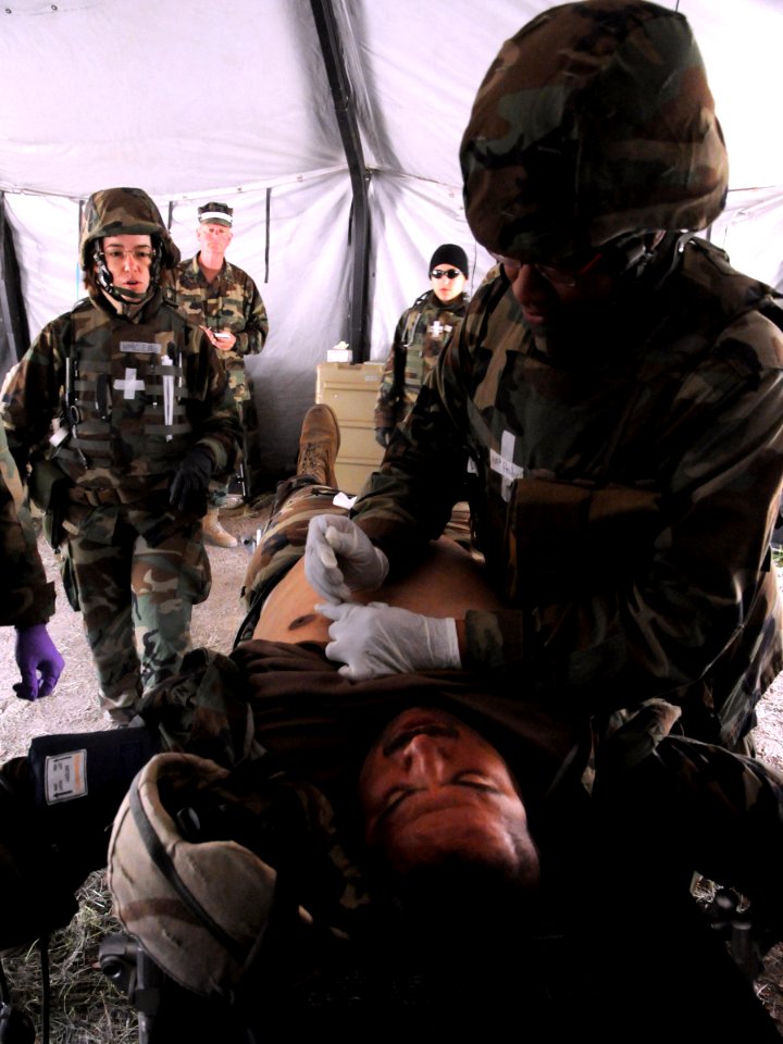 US Navy 090427-N-9584H-004 A corpsman assigned to Naval Mobile Construction Battalion (NMCB) 22 stabilizes a Seabee during an Operation Bearing Duel 2009 mass casualty drill