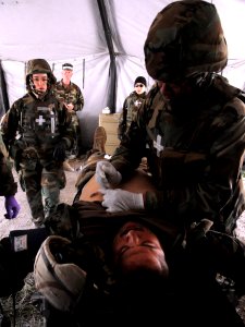 US Navy 090427-N-9584H-004 A corpsman assigned to Naval Mobile Construction Battalion (NMCB) 22 stabilizes a Seabee during an Operation Bearing Duel 2009 mass casualty drill