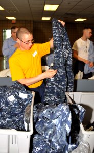 US Navy 090430-N-8848T-944 Seaman Recruit Christopher Santini, from Oregon City, Ore., examines his newly issued navy working uniform at Recruit Training Command