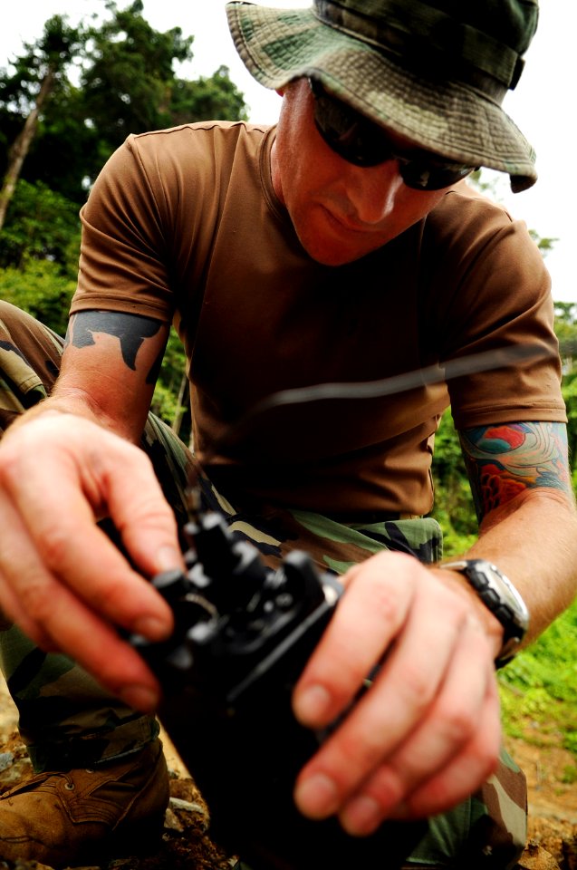 US Navy 090430-N-7130B-289 Chief Explosive Ordnance Disposal Technician Kenneth Simpson checks the connection of electric blasting cap leads to a wireless receiver during the disposal of live ordnance by members of the Philippi photo