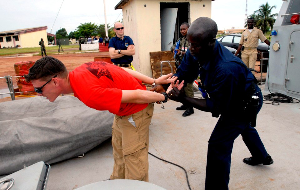 US Navy 090429-N-7948C-028 Aviation Boatswain's Mate (Fuels) 3rd Class Faron Goff is handcuffed by a Gabonese sailor during an Africa Partnership Station Nashville visit, board, search and seizure workshop in Port Gentil