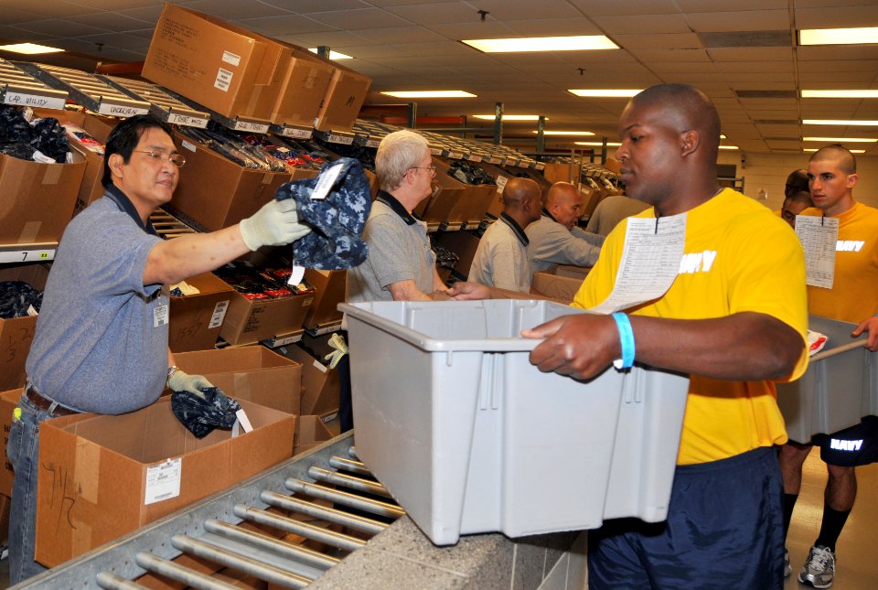 US Navy 090430-N-8848T-956 Enrique Garlit issues a recruit an eight-point cover for the new navy working uniform