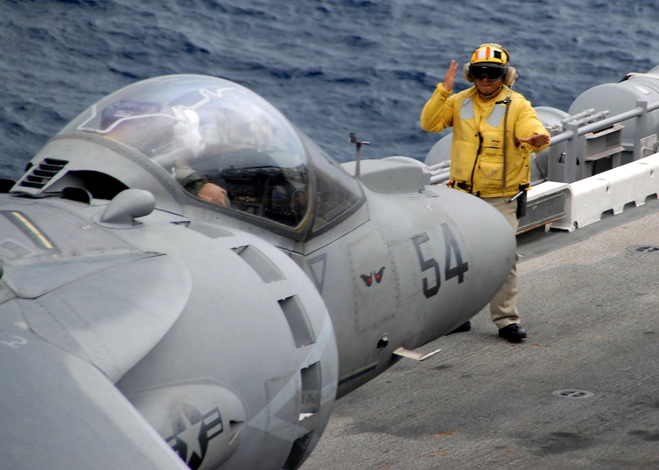 US Navy 090503-N-8283S-523 Chief Aviation Boatswain's Mate (Handling) Reginald Anies guides an AV-8B Harrier assigned to the Evil Eyes of Marine Medium Helicopter squadron (HMM) 163 (Reinforced)