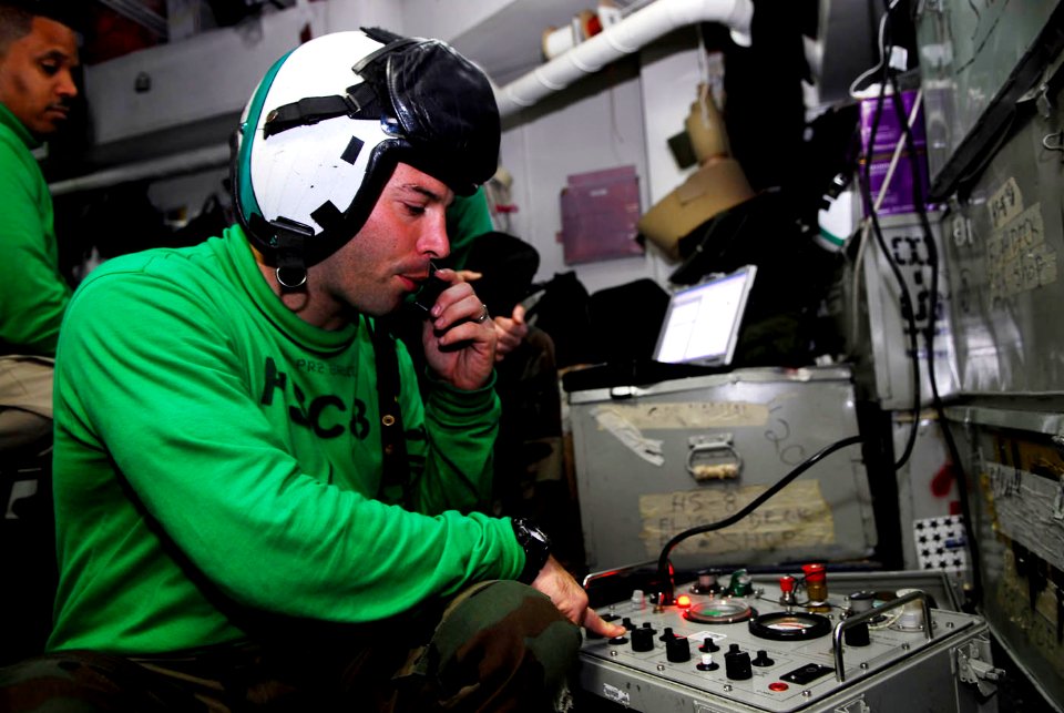 US Navy 090505-N-2475A-002 Aircrew Survival Equipmentman 2nd Class Jason Bruce, from San Diego, Calif., checks the internal communication systems on an HGU-84-P helmet for the Eightballers of Helicopter Sea Combat Squadron (HSC