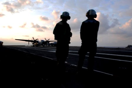 US Navy 090504-N-6538W-177 Aviation Boatswain's Mate Airman Andrew Sallee, left, from Parma, Idaho, and Aviation Boatswain's Mate 3rd Class John Symonds, from Houston, Texas, watch as a C-2A Greyhound lands aboard the aircraft