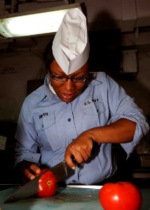 US Navy 090504-N-1062H-016 Culinary Specialist Seaman Apprentice Jackie Brown of S-2 Division slices tomatoes in the aft mess deck of USS George Washington (CVN 73)