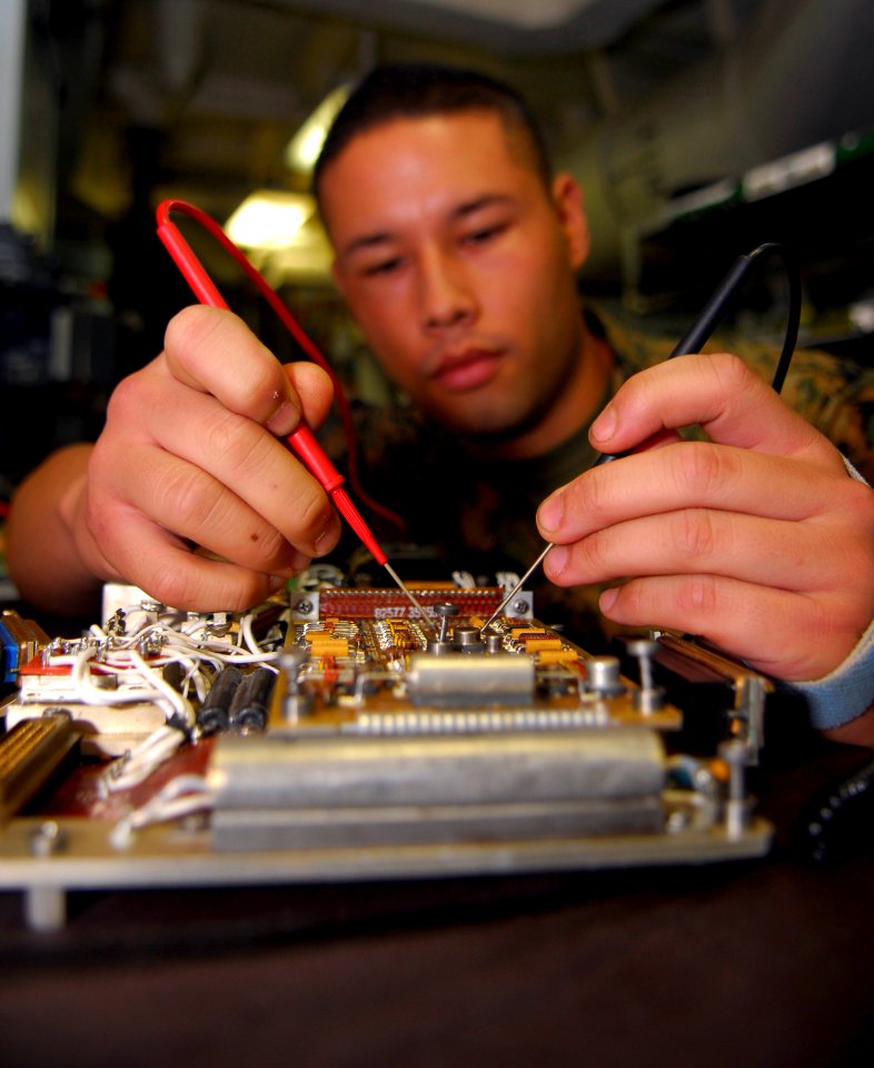 US Navy 090506-N-0096C-025 Sgt. Steven Quitugua, from Sacramento, Calif. assigned to the Death Rattlers of Marine Strike Fighter Squadron (VMFA) 323, checks an aircraft electronic component's resistance an avionics shop aboard