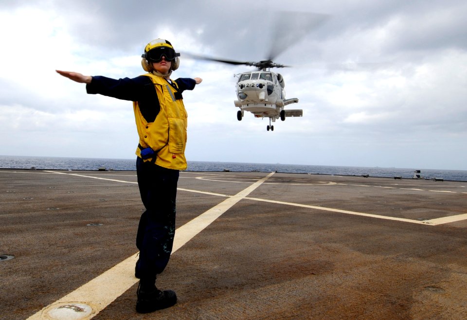 US Navy 090502-N-7478G-182 Boatswain's Mate 3rd Class Christine Bagley, assigned to the amphibious command ship USS Blue Ridge (LCC 19), launches a helicopter carrying Japan Maritime Self-Defense Force Rear Adm. Hitoshi Noguchi