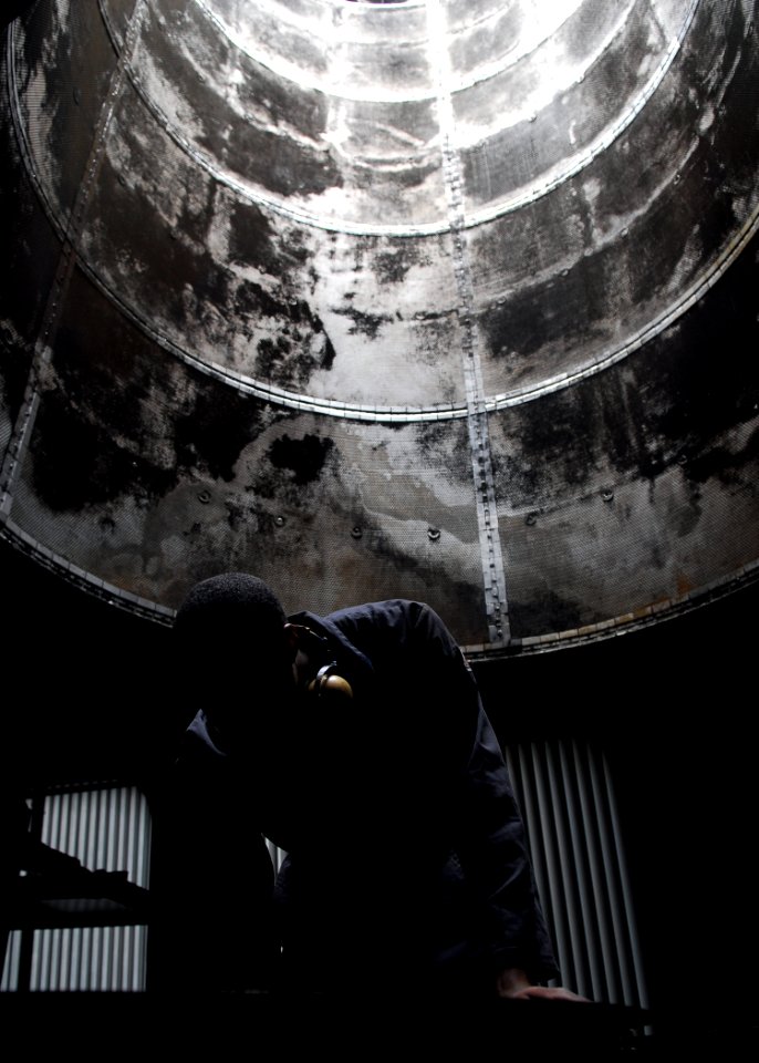 US Navy 090505-N-2013O-043 Gas Turbine Systems Technician (Mechanical) 3rd Class Brian Caver, from San Diego, inspects an gas turbine engine exhaust pipe inside the uptake room aboard the Arleigh Burke class guided missile dest