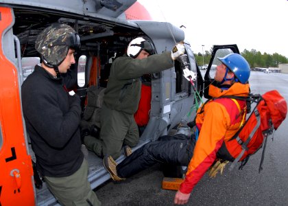 US Navy 090505-N-9860Y-003 Naval Aircrewman 1st Class Chad Lewis and Naval Aircrewman 1st Class Andrew Worth assist a Bellingham Mountain Rescue Council volunteer during a static hoist demonstration