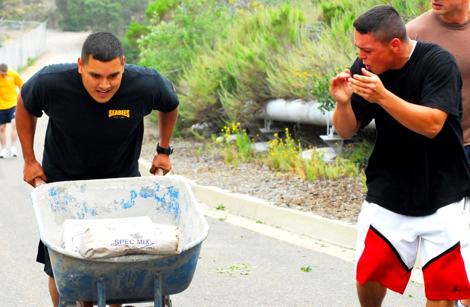 US Navy 090508-N-2183K-046 Cheered on by his teammates, Engineering Aide Constructionman Telly Armstrong pushes a wheel barrel filled with 188 pounds of cement mix