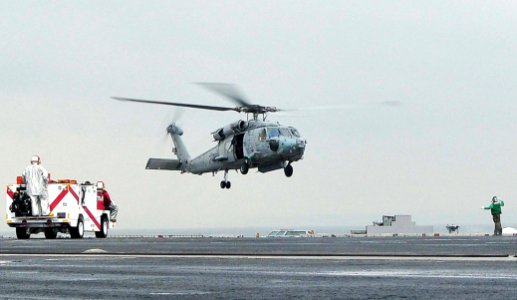 US Navy 090506-N-6233C-068 A Sailor assigned to the Chargers of Helicopter Anti-Submarine Squadron (HS) 14 directs an HH-60H Seahawk helicopter for a landing aboard the aircraft carrier USS George Washington (CVN 73)