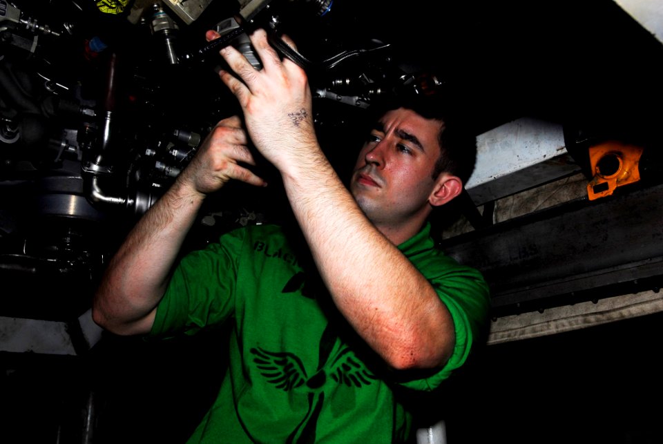 US Navy 090508-N-2475A-016 PACIFIC OCEAN (May 8, 2009) Aviation Machinist's Mate 2nd Class Anthony Blackner, from Jacksonville, Fla., installs an accessory gearbox drain adapter on an F414-GE-400