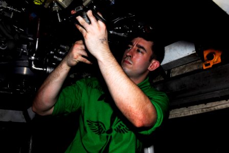 US Navy 090508-N-2475A-016 PACIFIC OCEAN (May 8, 2009) Aviation Machinist's Mate 2nd Class Anthony Blackner, from Jacksonville, Fla., installs an accessory gearbox drain adapter on an F414-GE-400
