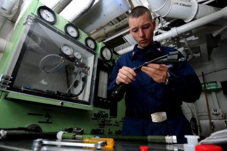 US Navy 090513-N-3946H-107 PACIFIC OCEAN (May 13, 2009) Aircrew Survival Equipmentman 2nd Class James Shoemaker inspects oxygen regulator hoses prior to a pressure decay test photo