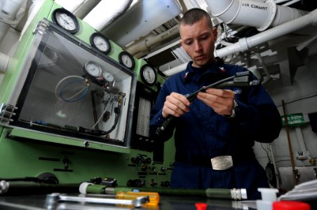 US Navy 090513-N-3946H-107 PACIFIC OCEAN (May 13, 2009) Aircrew Survival Equipmentman 2nd Class James Shoemaker inspects oxygen regulator hoses prior to a pressure decay test