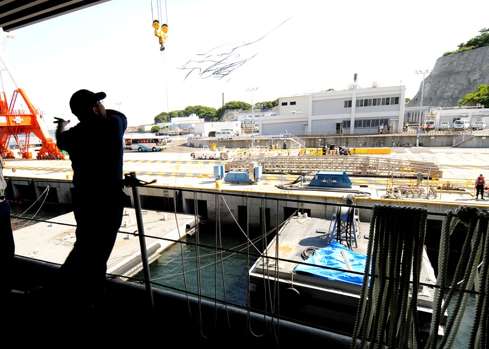 US Navy 090515-N-1062H-020 Seaman Domingo Montilla throws the heaving line to Sailors pier-side to moor USS George Washington (CVN 73)