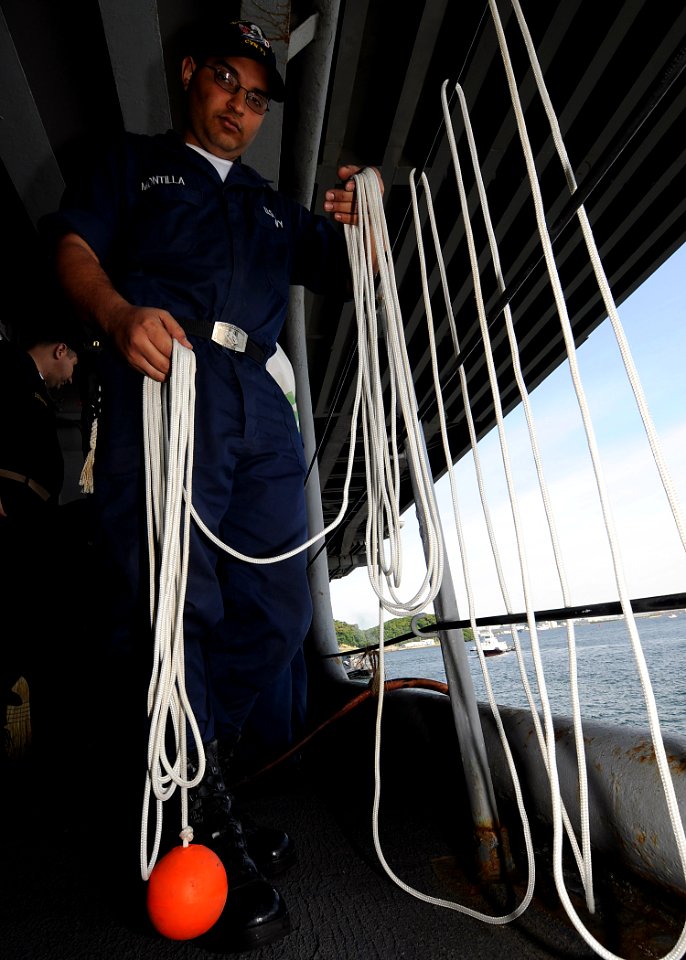 US Navy 090515-N-1062H-006 Seaman Domingo Montilla readies the heaving line for mooring USS George Washington (CVN 73)