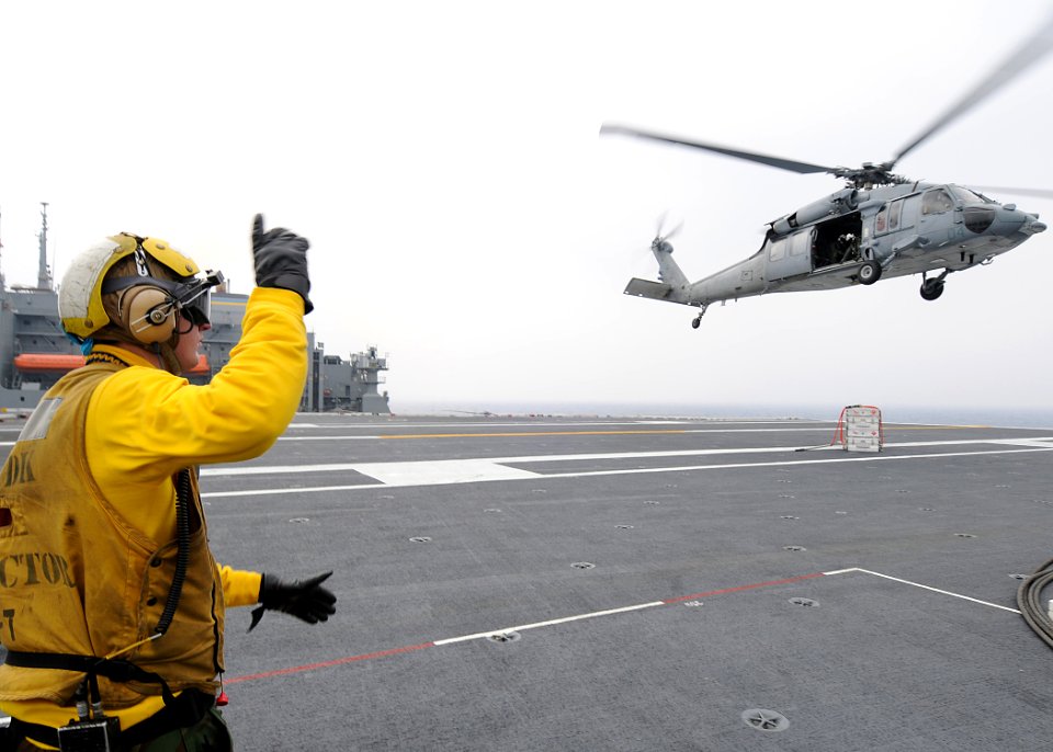 US Navy 090511-N-1062H-106 PACIFIC OCEAN (May 11, 2009) Aviation Boatswain's Mate (Handling) 2nd Class Andrew Hill directs an MH-60S Sea Hawk helicopter