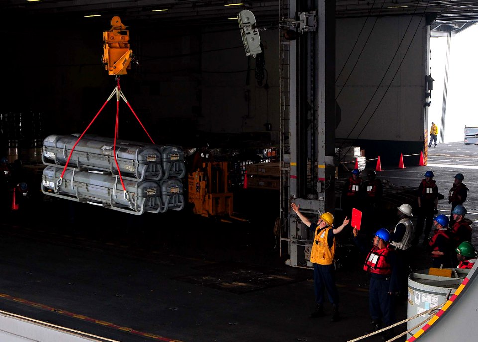 US Navy 090511-N-6233C-012 Boatswain's Mate 3rd Class Elliot Powers gives a safe distance signal during a munitions transfer from the Military Sealift Command dry cargo-ammunition ship USNS Alan Shepard (T-AKE 3) to the aircraf