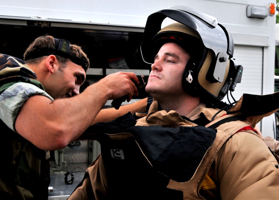 US Navy 090512-N-2013O-057 Lt. Wade Hilderbrand, from Portland, Ore., a member of Explosive Ordnance Disposal Mobile Unit 5, Det. Japan, helps Explosive Ordnance Disposal Technician 1st Class Taylor King, from Concorde, N.C., d
