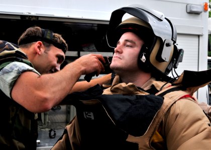 US Navy 090512-N-2013O-057 Lt. Wade Hilderbrand, from Portland, Ore., a member of Explosive Ordnance Disposal Mobile Unit 5, Det. Japan, helps Explosive Ordnance Disposal Technician 1st Class Taylor King, from Concorde, N.C., d
