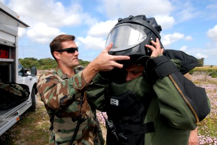 US Navy 090514-N-2013O-173 Lt. Matthew Coombs, officer in charge of Explosive Ordnance Disposal Mobile Unit (EODMU) 8, Det. Europe, helps an explosive ordnance disposal technician with Spain's Unidad Especial Desactivado de Exp photo