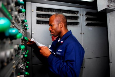 US Navy 090513-N-0096C-019 Electrician's Mate 2nd Class James Osibogun, from New York, N.Y., performs preventive maintenance on a ventilation control panel photo