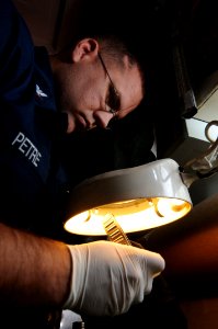US Navy 090513-N-3946H-054 PACIFIC OCEAN (May 13, 2009) Aviation Structural Mechanic 3rd Class Trever Petre uses a magnifying glass to inspect the bearings of an F-A-18 Hornet tire photo