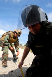 US Navy 090514-N-3289C-120 Technician 1st Class Luigi Mendoza, assigned to Explosive Ordnance Disposal Mobile Unit (EODMU) 8 Det. Europe, measure distance from a simulated Improvised Explosive Device photo