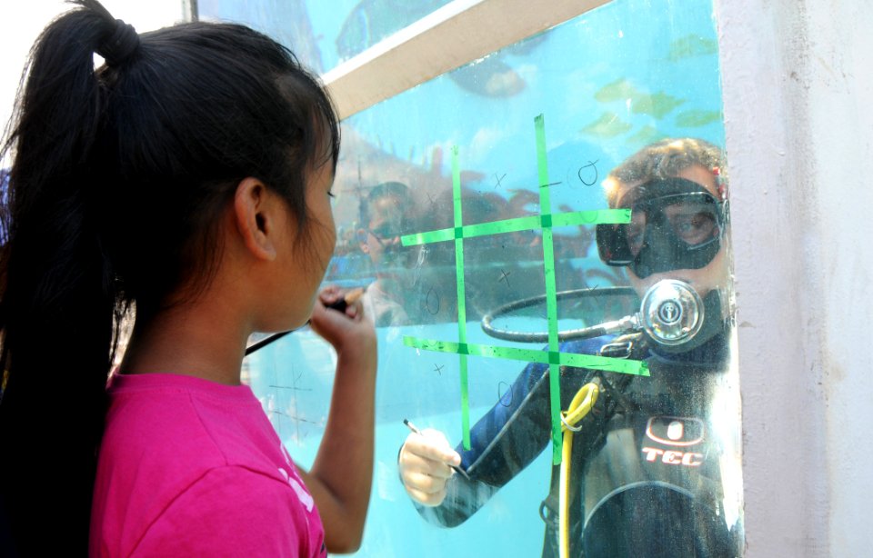 US Navy 090515-N-3666S-024 A student from Waipahu Elementary School plays underwater tic-tac-toe with a Sailor assigned to Mobile Diving and Salvage Unit (MDSU) 1 at Merry Point Landing at Naval Station Pearl Harbor