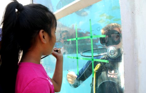 US Navy 090515-N-3666S-024 A student from Waipahu Elementary School plays underwater tic-tac-toe with a Sailor assigned to Mobile Diving and Salvage Unit (MDSU) 1 at Merry Point Landing at Naval Station Pearl Harbor