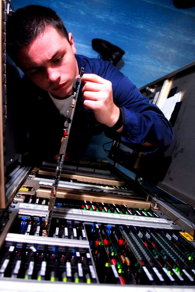 US Navy 090516-N-2475A-065 Electronics Technician 3rd Class Ernesto DeLeon, from Salem, Ore., inspects the captain's touch entry display interface card in Radar Switchboard Room 2 aboard the aircraft carrier USS John C. Stennis