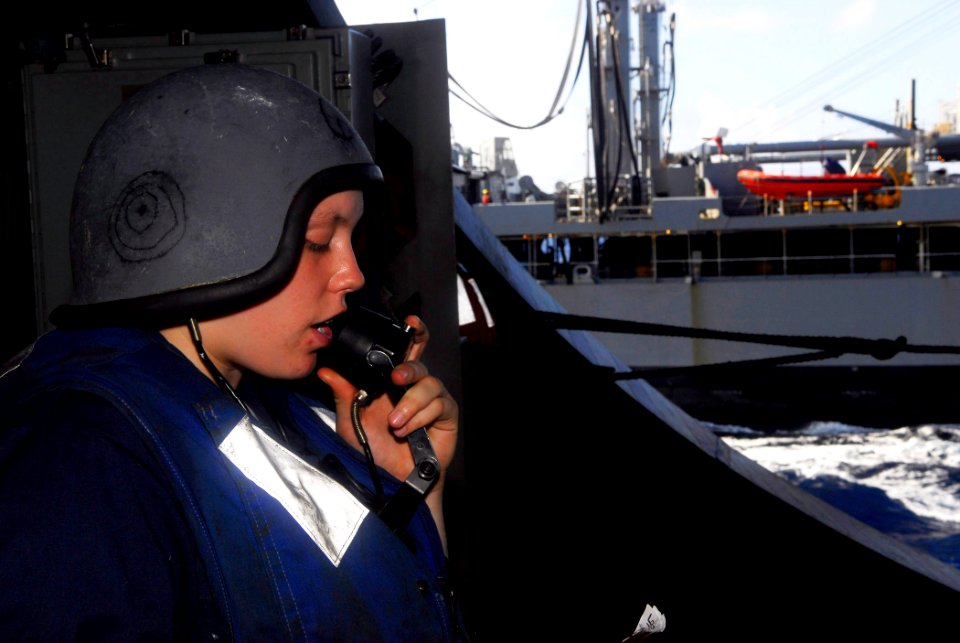 US Navy 090515-N-2475A-043 Fireman Elizabeth Aceto, from Boston, uses a sound-powered phone to communicate with the bridge and deck control as supplies are received in the hangar bay aboard the aircraft carrier USS John C. Sten