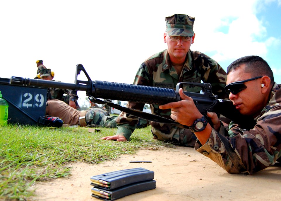US Navy 090518-N-1120L-007 Religious Program Specialist 2nd Class Michael Pornovets, a range coach for Naval Mobile Construction Battalion (NMCB) 7, watches Storekeeper 2nd Class Shawn Apgar as he sights in his M16A2 service ri