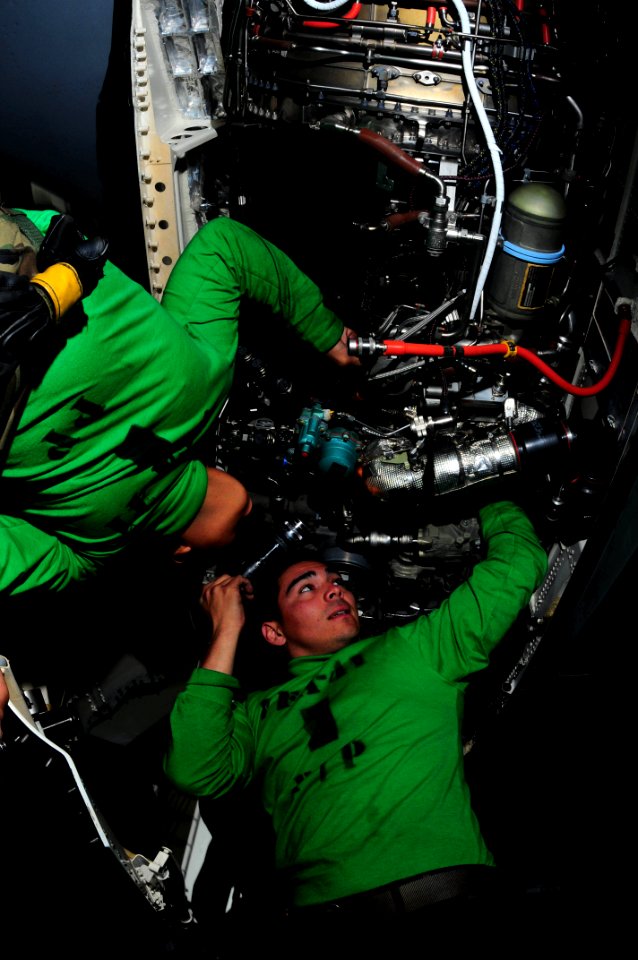 US Navy 090518-N-3946H-044 Aviation Machinist's Mate 2nd Class Norland Obillo and Aviation Machinist's Mate 3rd Class David Carbajal install a fuel line in the engine of an F-A-18F Super Hornet