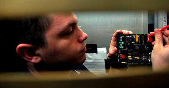 US Navy 090516-N-2475A-047 Electronics Technician 3rd Class Ernesto DeLeon, from Salem, Ore., adjusts the captain's touch entry display interface card in Radar Switchboard Room 2 aboard the aircraft carrier USS John C. Stennis
