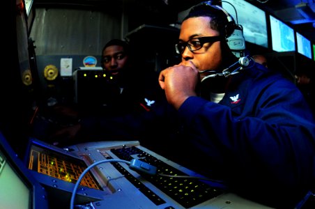 US Navy 090518-N-3946H-091 Operations Specialist 3rd Class Quincy Smith and Operations Specialist 3rd Class Reginald Sanders track local aircraft movement in the Combat Direction Center (CDC) of the aircraft carrier USS Nimitz photo