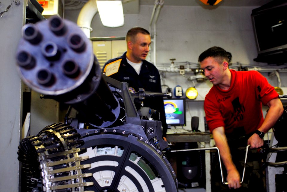 US Navy 090519-N-9610C-036 Aviation Ordnanceman 1st Class Vertis Davis, left, from Rapid City, R.I., shows Navy ROTC Midshipman 2nd Class Brian Isbell, from Auburn University, how to cycle dummy rounds into an M61A2 20mm Gatlin