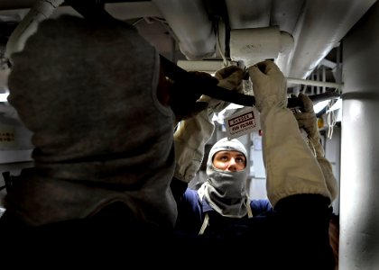 US Navy 090518-N-7280V-194 Seaman Elando Spouldings and Seaman Robert Daub hang high-voltage tags as they rig casualty power to the aft close-in weapons system (CIWS) during a general quarters drill
